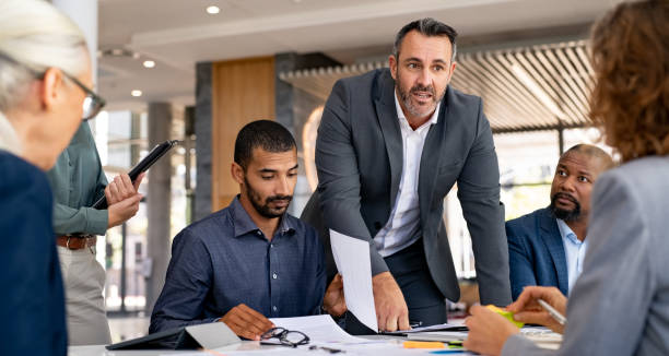 Business leader briefing a team around a meeting table